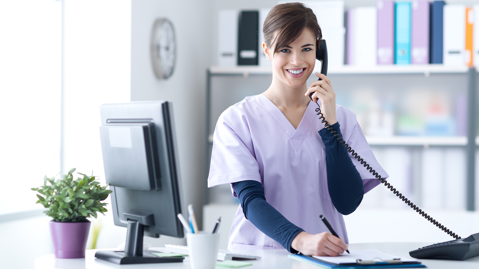 Henderson Primary Care provider documenting patient records on a clipboard